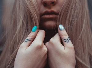Girl with detailed tattoos on her thumbs