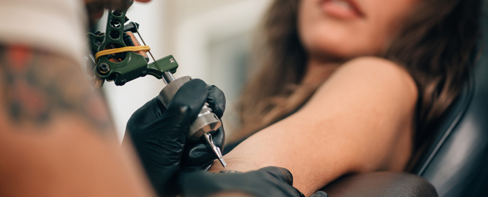 Una clienta comenzando un tatuaje en la parte superior del brazo
