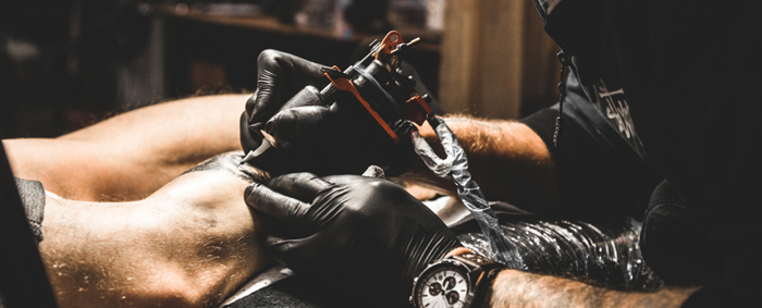 A professional tattoo artist applying black ink