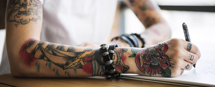 A tattoo artist working on a drawing