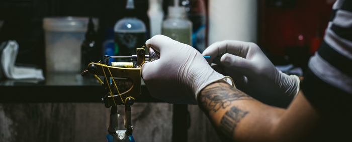 Tätowierer beim Tattoo-Maschine reinigen
