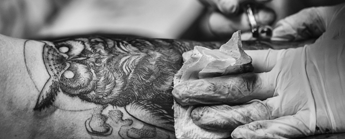 An owl tattoo being tattooed