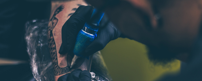 Male artist with beard working on a tattoo