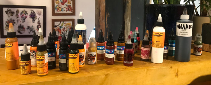 Bottles of tattoo ink on a desk.