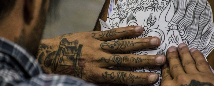 Tattoo artist putting stencil on customer.