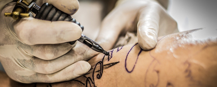 Close-up of a leg getting tattooed.