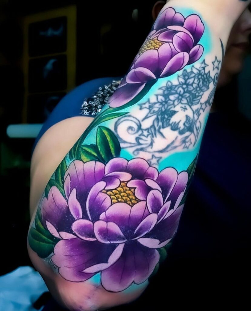 Forearm tattoo showing a colourful flower.